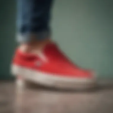 Side view of red suede Vans slip-ons on a stylish outfit